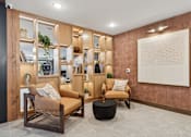Thumbnail 61 of 103 - A living room with a brown sofa, a wooden chair, and a large painting on the wall.