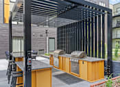 Thumbnail 92 of 103 - A modern outdoor kitchen with a grill and sink.