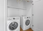 Thumbnail 21 of 103 - a white laundry room with a washing machine and a washer and dryer