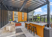 Thumbnail 88 of 103 - A patio with a bar and stools under a roof.
