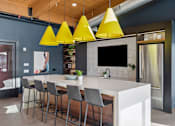 Thumbnail 49 of 99 - A modern kitchen with a white countertop and grey bar stools.