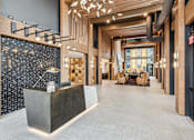 Thumbnail 55 of 103 - A modern lobby with a reception desk and a large window.