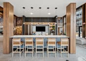 Thumbnail 44 of 103 - A modern kitchen with a bar area and wooden chairs.