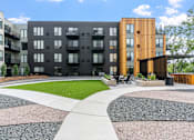 Thumbnail 89 of 103 - A modern apartment complex with a mix of black and wooden buildings.