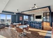 Thumbnail 55 of 99 - A modern living room with a bar area and a view of the city.