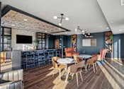 Thumbnail 52 of 99 - A modern dining area with a bar and a television.
