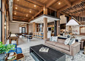 Thumbnail 52 of 103 - A living room with a brown couch and a black coffee table.