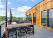 Thumbnail 79 of 103 - A patio with a table and chairs overlooking a green landscape.