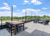 Thumbnail 82 of 103 - A patio with a table and chairs is set up on a balcony.