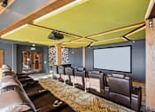 Thumbnail 37 of 99 - A home theater with a row of brown leather chairs and a large screen.