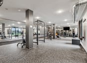Thumbnail 31 of 103 - A gym with a variety of equipment including treadmills, weights, and exercise machines.
