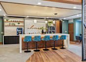 Thumbnail 25 of 99 - A bar area with blue chairs and a counter.