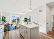 Thumbnail 64 of 99 - A kitchen with a large island and pendant lights.
