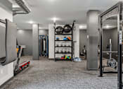 Thumbnail 38 of 103 - A gym with a variety of equipment including weights and a treadmill.
