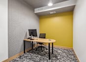 Thumbnail 37 of 103 - A desk with a computer monitor and keyboard sits in a room with a patterned wallpaper.