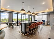 Thumbnail 68 of 103 - A modern kitchen with a bar area and chairs.