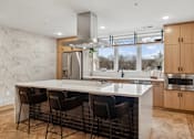 Thumbnail 39 of 103 - A modern kitchen with a large island and chairs.