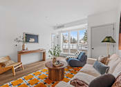 Thumbnail 108 of 113 - A living room with a white couch and a wooden coffee table.