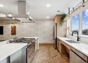 Thumbnail 43 of 103 - A modern kitchen with a white countertop and wooden flooring.