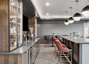 Thumbnail 42 of 103 - A modern kitchen with a bar area and seating.