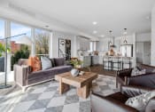 Thumbnail 8 of 103 - a living room with couches and a coffee table in front of a kitchen
