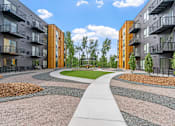 Thumbnail 99 of 103 - A modern apartment complex with a central walkway and landscaped gardens.