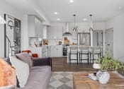 Thumbnail 7 of 103 - a living room with a couch and a kitchen with an island