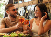 Thumbnail 26 of 103 - a man and a woman sitting at a table with drinks
