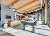 Thumbnail 4 of 55 - A modern living room with a pool table and a television.