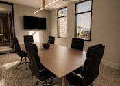 Thumbnail 59 of 85 - A conference room with a large table and chairs.