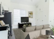 Thumbnail 13 of 29 - Living Room with a Couch and TV at The Arza Apartments