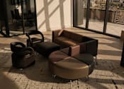 Thumbnail 60 of 85 - A living room with a brown couch, ottoman, and chair.