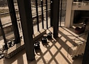 Thumbnail 58 of 85 - A view of a room with a lot of windows and a few objects on the floor.