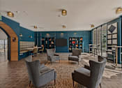 Thumbnail 43 of 85 - A living room with grey chairs and a wooden floor.