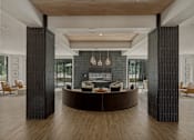 Thumbnail 27 of 85 - A modern living room with a curved wooden coffee table and a dark grey wall.