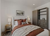 Thumbnail 4 of 85 - A bedroom with a large bed and a wooden nightstand.