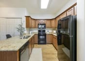 Thumbnail 3 of 23 - Kitchen with Black Appliances at Falls at Riverwoods