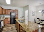 Thumbnail 2 of 31 - Kitchen with Brown Cabinets at San Tropez