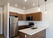 Thumbnail 20 of 52 - Kitchen with Brown Cabinets at The Ash Apartments & Townhomes