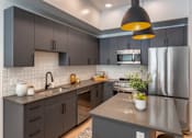 Thumbnail 1 of 34 - Kitchen with Dark Accents at Maye House Apartments