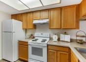 Thumbnail 6 of 29 - Kitchen with White Appliances at Aztec Springs
