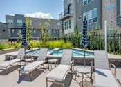 Thumbnail 15 of 39 - Lounge Chairs Facing Pool at The Austin Townhomes