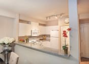 Thumbnail 11 of 40 - Open kitchen with updated white appliances at Metropolitan Collection Apartments, Washington, 98057