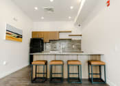 Thumbnail 14 of 25 - Community Kitchen with Island & Wood Grain Cabinets at Meadows at Homestead Logan UT