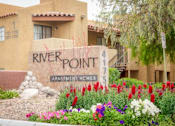 Thumbnail 1 of 18 - Welcoming Entry Signage with Flowers at River Point Apartments, Tucson, AZ, 85712