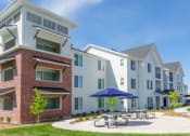 Thumbnail 19 of 39 - Building Exterior View with Picnic Area at Rivulet Apartments, Utah