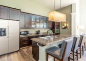 Thumbnail 35 of 39 - Clubhouse Kitchen with Island and Double Door Refrigerator at San Tropez Apartments & Townhomes, South Jordan