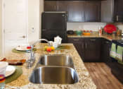 Thumbnail 2 of 38 - Modern Kitchen with Granite Countertops and Upgraded Black Appliances r at Talavera at the Junction Apartments & Townhomes, Utah, 84047