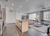 Thumbnail 14 of 45 - A modern kitchen with a refrigerator on the left and a dining area with a glass table and chairs.