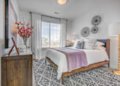Thumbnail 18 of 45 - A bedroom with a large bed and a wooden dresser.